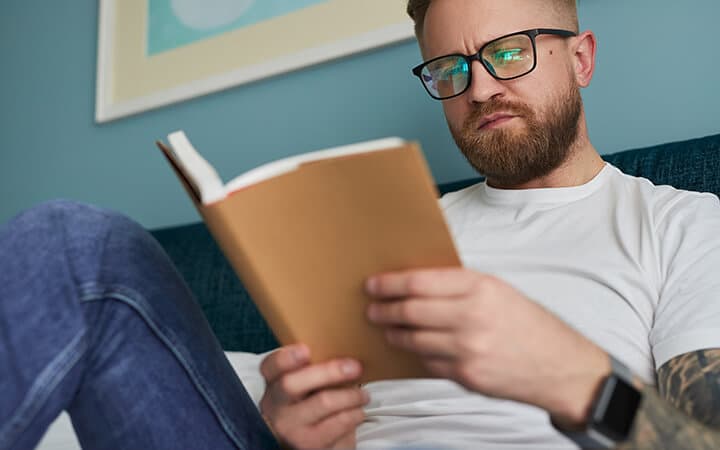 beard guy reading a book patiently